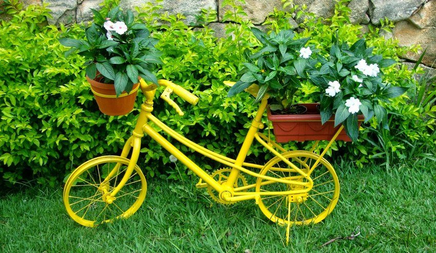 Старый велосипед, выкрашенный в яркий цвет, – отличный вариант для устройства цветника